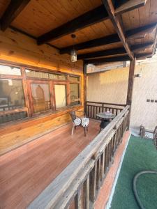 a wooden porch with a bench on a wooden deck at اكواخ بيلا 2 in Taif