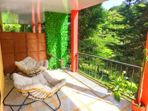 two chairs on a balcony with a view of trees at Kenai Mountain View in Concepción