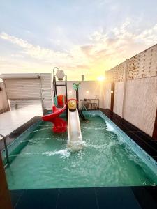 a pool with a water slide on a rooftop at اكواخ بيلا 2 in Taif