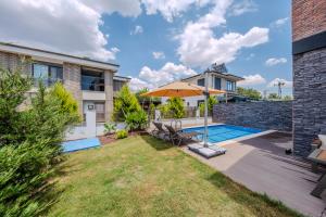 a backyard with a swimming pool and an umbrella at Luxury Forest Villas with Private Pool in Antalya