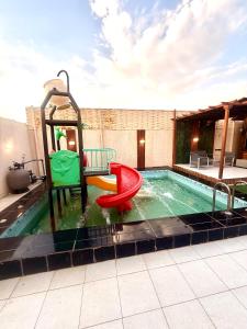 a pool with a slide and a playground at اكواخ بيلا 2 in Taif +7 photos