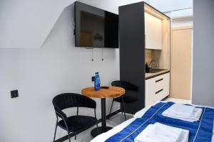 a small room with a table and chairs and a kitchen at Cobalt Apartments in Mikołajki