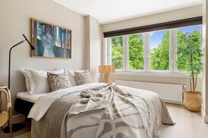 a bedroom with a bed and two windows at Voy Stays Molde sentrum in Molde