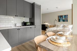 a kitchen and living room with a table and a bed at Voy Stays Molde sentrum in Molde +11 photos