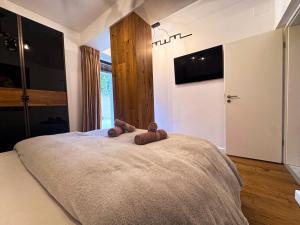 a bedroom with a large bed with two teddy bears on it at Luxury Apartments C in Braşov