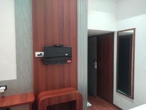 a room with a tv on a wooden wall at Hotel Sweet Inn in Mumbai