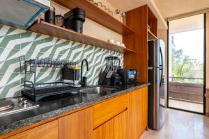 a kitchen with a sink and a refrigerator at BT Homes - Tankah Bay Tulum - Exclusivos apartamentos con piscina a metros del mar in Tancah