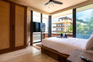 a bedroom with a large bed and a large window at BT Homes - Tankah Bay Tulum - Exclusivos apartamentos con piscina a metros del mar in Tancah