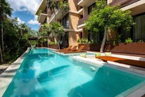 a swimming pool in front of a building at BT Homes - Tankah Bay Tulum - Exclusivos apartamentos con piscina a metros del mar in Tancah +115 photos
