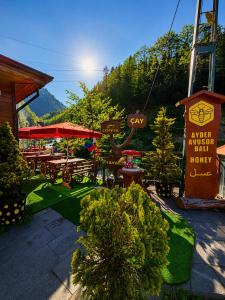 a restaurant with tables and chairs and a sign at Ayder Avusor Hotel in Ayder Yaylasi