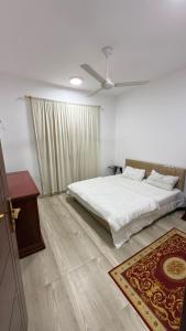 a bedroom with a bed and a ceiling fan at صلالة صحلنوت in Salalah