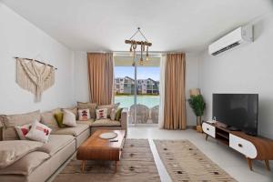a living room with a couch and a tv at Fouka Bay Holiday Apartments By BlueKeys in Marsa Matruh