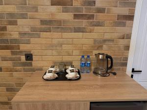 Eine Küchentheke mit zwei Tellern und einem Wasserkocher in der Unterkunft Rıver Forest Hotel in İsmayıllı