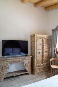 a living room with a television and a wooden cabinet at Glamping Tenuta Ca'Nova in Mestrino