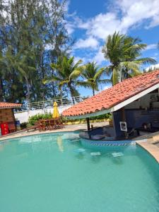 a large swimming pool next to a house with palm trees at Girassol praia hotel in Valença