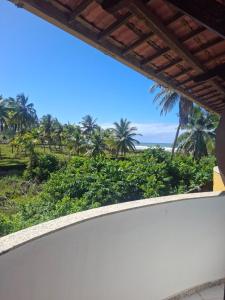 a view from the balcony of a resort with palm trees at Girassol praia hotel in Valença