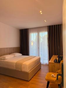 a bedroom with a bed and a large window at Villa SkyWay in Krujë