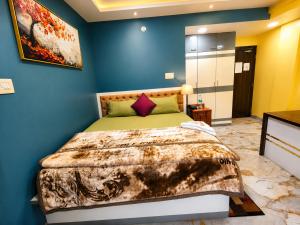 a bedroom with a bed with a blue wall at NHM Stays in Garui