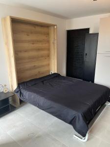 a large bed in a room with a wooden door at Le studio signature in Vedène