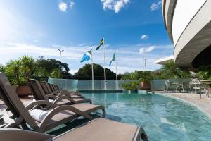 a swimming pool with chairs and flags on a building at Deville Prime Campo Grande in Campo Grande
