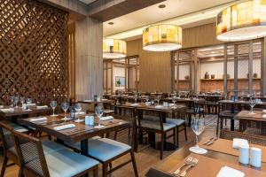 a restaurant with wooden tables and chairs and chandeliers at Deville Prime Campo Grande in Campo Grande