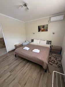 a bedroom with a bed with two towels on it at Hotel ELYSIUM in Irshava