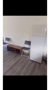 a room with two chairs and a table and a desk at Hafi in Païta