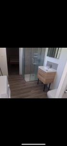 a bathroom with a sink and a glass shower at Hafi in Païta