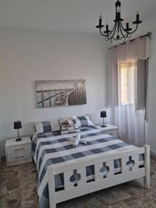 a bedroom with a blue and white bed and a chandelier at Casa rias baixas in Poio