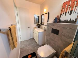 a bathroom with a white toilet and a sink at Charming 3BR Beverly Retreat with Large Private Backyard Bedford in Los Angeles +23 photos