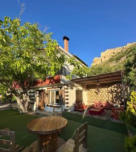 ein Haus mit einer Terrasse und einem Tisch im Garten in der Unterkunft Arida farm in Bischarri