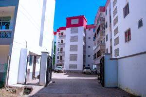 an alley between buildings in a city with cars at Stylish Mtwapa Studio with Rooftop Pool View in Mtwapa