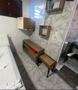 a bathroom with a bed and a small table in it at Pousada do Benzinho in Cabedelo