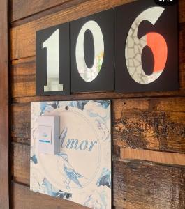 a wooden wall with a number and a picture at Pousada do Benzinho in Cabedelo