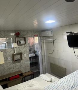 a room with a bed and a tv in a room at Pousada do Benzinho in Cabedelo