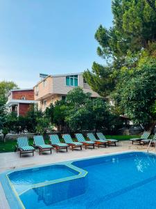 a group of lounge chairs next to a swimming pool at Garden Prizma Apart in Kemer