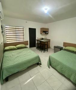 a bedroom with two beds and a desk in it at Depas Expo Estadio in Monterrey