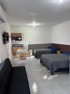 a room with two beds and a table and chairs at Depas Expo Estadio in Monterrey