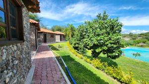 a stone house with a garden and a swimming pool at Cabaña Oasis Ixmiquilpan in Ixmiquilpan