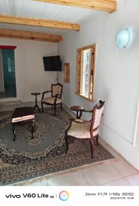 a living room with two chairs and a tv at Firehouse self-catering cottage 7 in Wellington