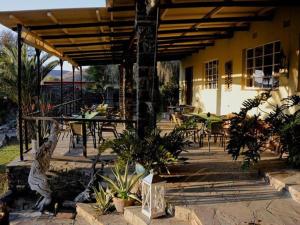 a patio with tables and chairs and a building at Zebra River Lodge in Maltahöhe