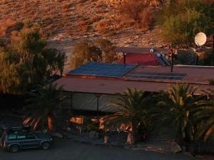a car parked in front of a building with solar panels at Zebra River Lodge in Maltahöhe