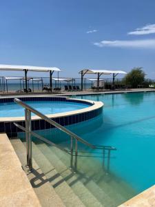two swimming pools with the ocean in the background at Atlantis Resort Коттеджи-таунхаузы in Chon-Sary-Oy