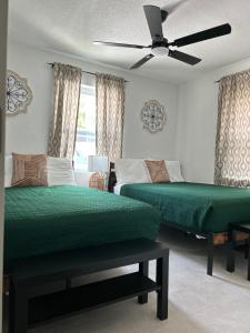 a bedroom with two beds and a ceiling fan at cozy bohemian in North Miami