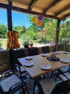 a wooden table and chairs on a patio at Studio apartman Hrast in Seline