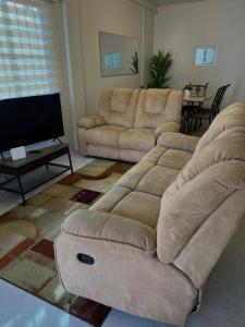 a living room with a couch and a flat screen tv at Golden Isles Paradise in Port-of-Spain