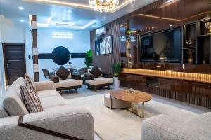 a living room with couches and a flat screen tv at CozyKeys luxurious Apartment in Abuja