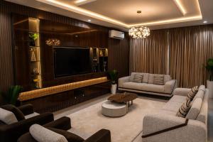 a living room with couches and a flat screen tv at CozyKeys luxurious Apartment in Abuja +6 photos