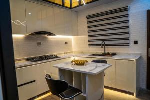 a kitchen with a island with chairs and a sink at CozyKeys luxurious Apartment in Abuja