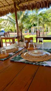 a wooden table with plates and glasses on top of it at The Jungle, Guriú, CE in Guriú